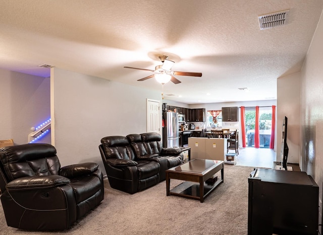 carpeted living room with a textured ceiling and ceiling fan