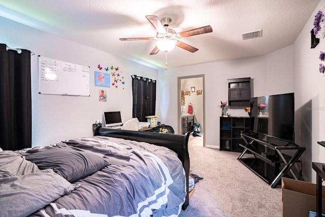 carpeted bedroom with ensuite bathroom, a textured ceiling, and ceiling fan