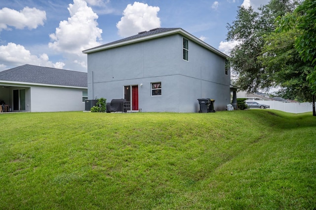 back of property with a lawn and central AC unit