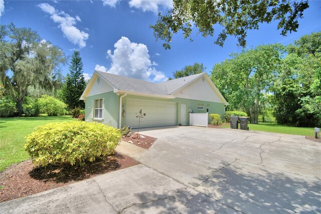 view of side of property featuring a garage and a lawn