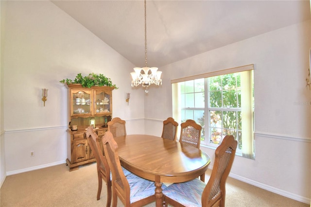 carpeted dining area featuring high vaulted ceiling and an inviting chandelier