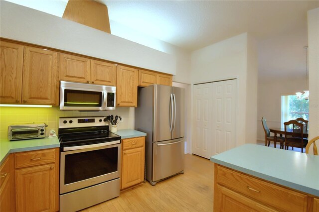 kitchen featuring appliances with stainless steel finishes, decorative backsplash, and light hardwood / wood-style floors