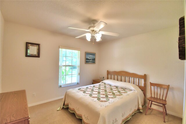 bedroom with ceiling fan and light colored carpet