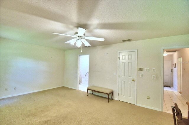 carpeted empty room with a textured ceiling and ceiling fan