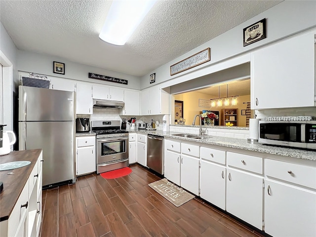 kitchen featuring appliances with stainless steel finishes, tasteful backsplash, white cabinetry, and sink