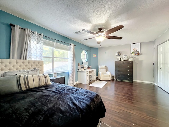 bedroom featuring a textured ceiling, dark hardwood / wood-style flooring, a closet, and ceiling fan