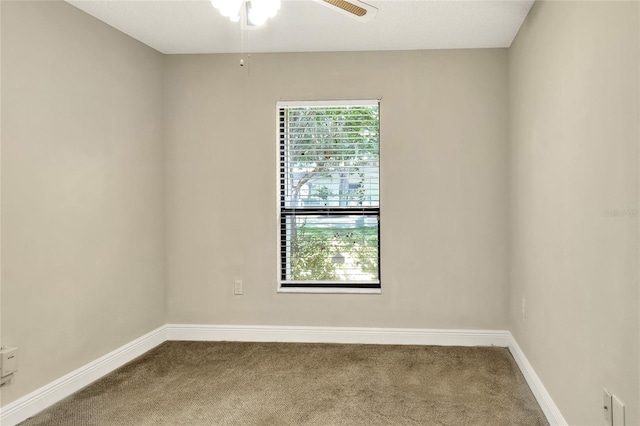 carpeted empty room with a ceiling fan and baseboards