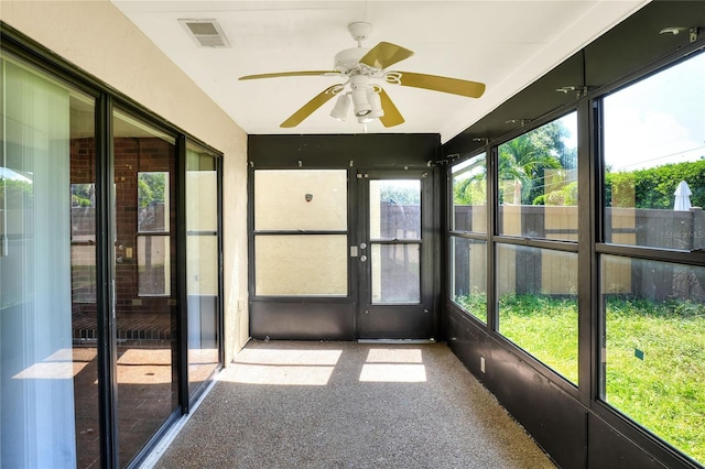 unfurnished sunroom with a ceiling fan and visible vents