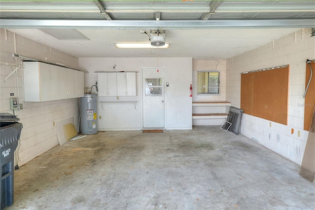 garage featuring a garage door opener, concrete block wall, and water heater