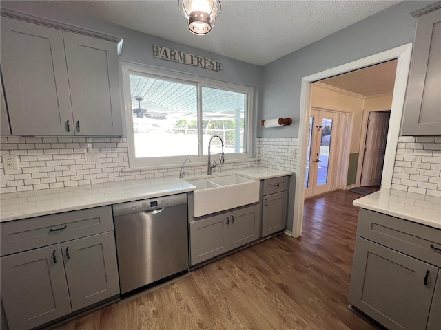 kitchen featuring gray cabinetry, stainless steel dishwasher, and a sink