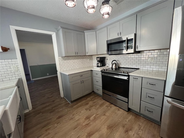kitchen with light countertops, gray cabinets, and appliances with stainless steel finishes