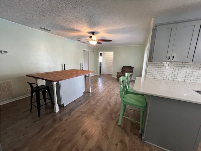 dining space with a textured ceiling, ceiling fan, and dark hardwood / wood-style floors