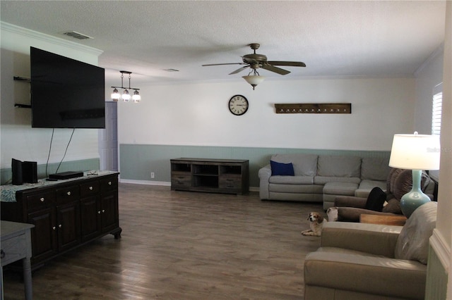 living room with dark wood-type flooring, ceiling fan with notable chandelier, crown molding, and a textured ceiling