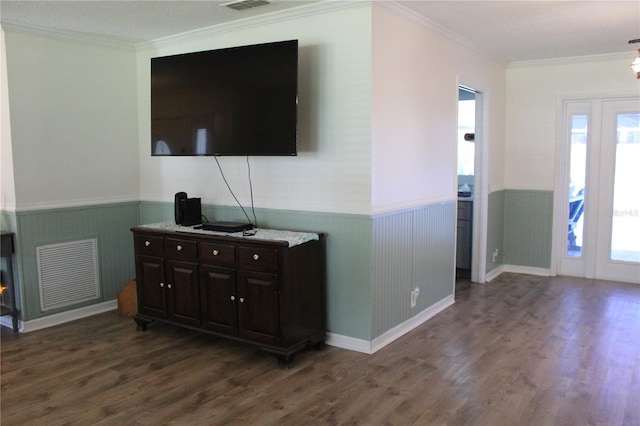 living room with a textured ceiling, dark wood-type flooring, a healthy amount of sunlight, and ornamental molding