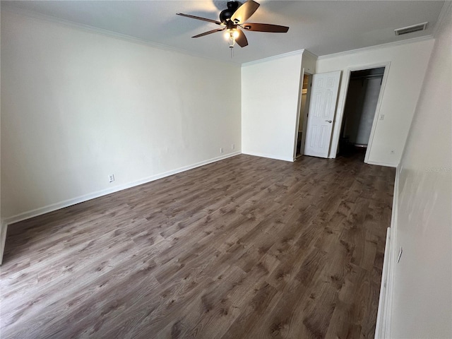 spare room featuring crown molding, dark wood-type flooring, and ceiling fan