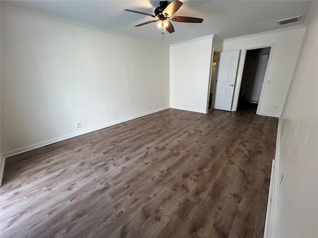 unfurnished bedroom featuring baseboards, ornamental molding, dark wood finished floors, and visible vents