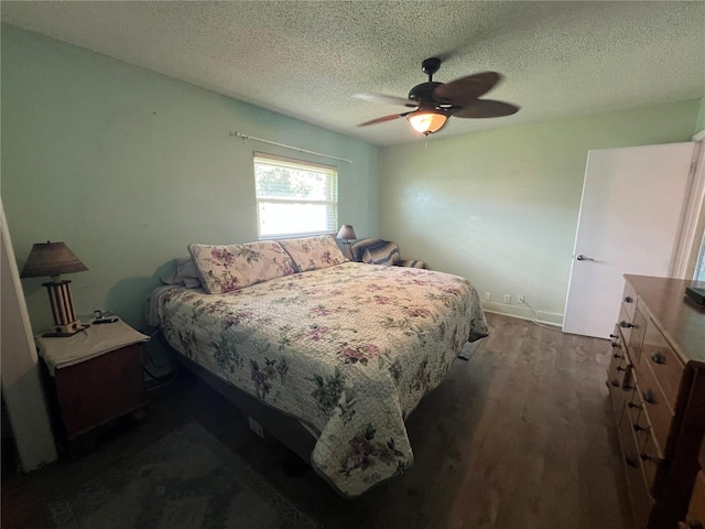 bedroom with a textured ceiling, a ceiling fan, and dark wood-style floors