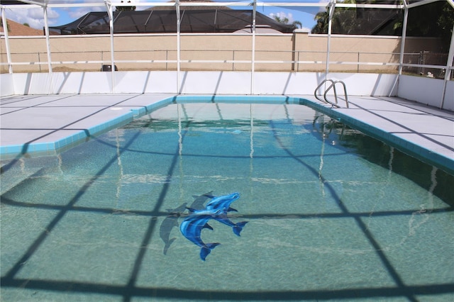 view of swimming pool featuring fence, a fenced in pool, and glass enclosure