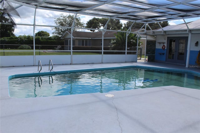 view of pool with glass enclosure, a patio, and french doors