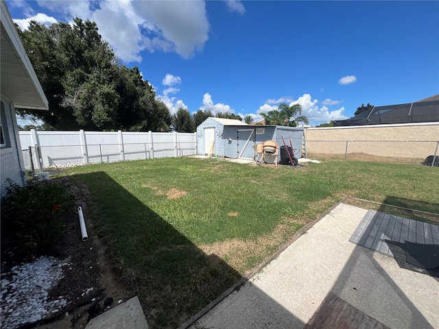 view of yard with a fenced backyard, an outdoor structure, and a storage shed
