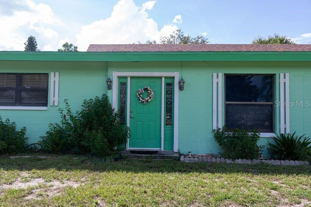 entrance to property featuring a lawn