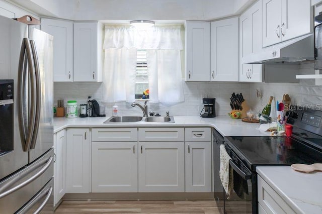 kitchen featuring stainless steel fridge with ice dispenser, electric range, white cabinetry, light hardwood / wood-style flooring, and sink