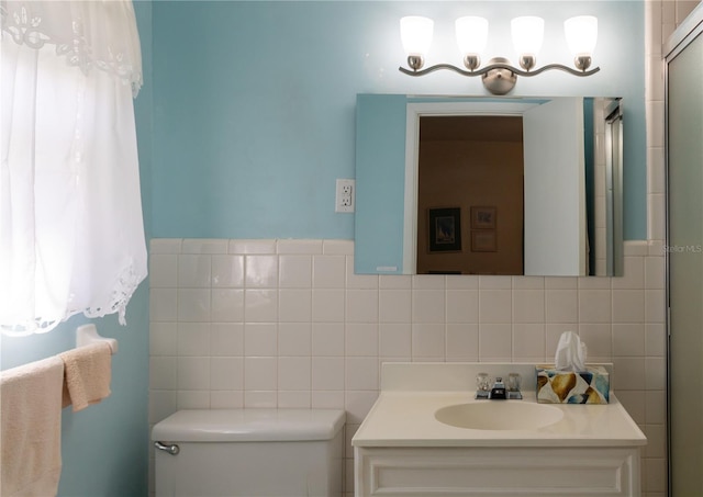 bathroom featuring vanity, backsplash, tile walls, and toilet