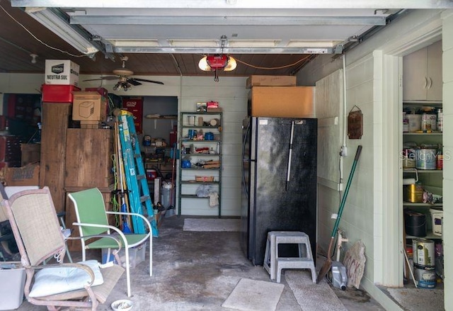 garage with a garage door opener, ceiling fan, and black refrigerator