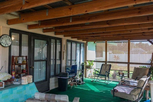 sunroom / solarium featuring lofted ceiling with beams