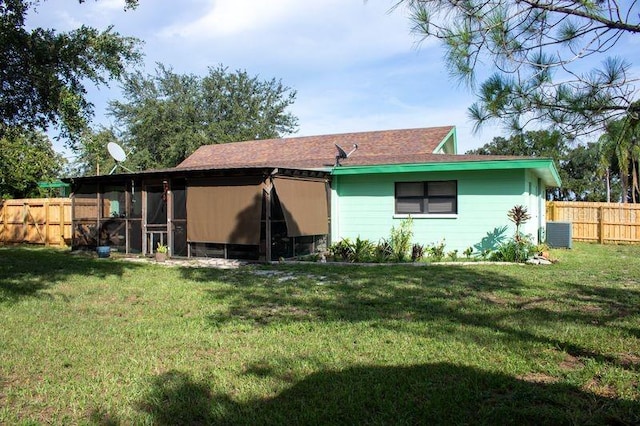 back of property with central air condition unit and a lawn