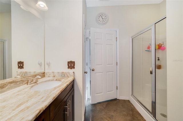 bathroom with a shower with door, vanity, and tile patterned floors