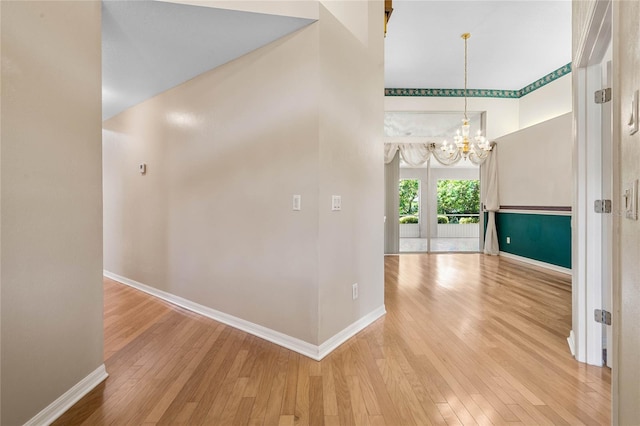 hall with a chandelier, a towering ceiling, and wood-type flooring