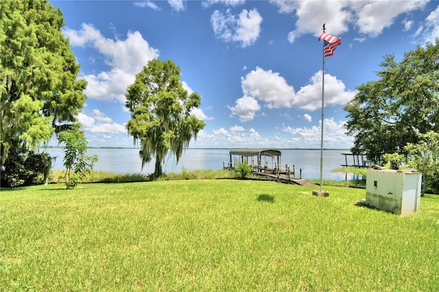 view of yard with a water view and a dock