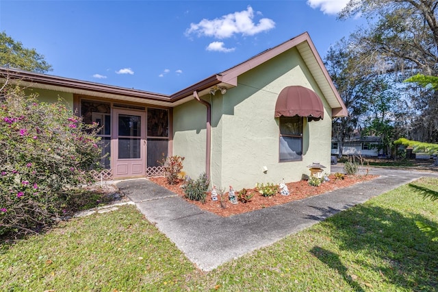 view of front of home with a front lawn and stucco siding