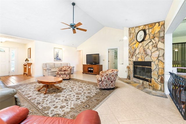 living room featuring a fireplace, high vaulted ceiling, a ceiling fan, and tile patterned floors