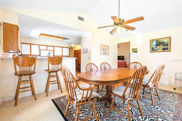 dining room with a ceiling fan, visible vents, vaulted ceiling, and baseboards