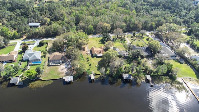 drone / aerial view featuring a water view, a residential view, and a view of trees