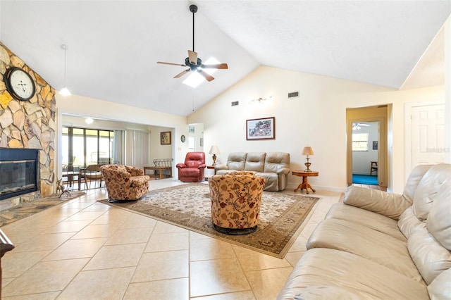 tiled living area featuring high vaulted ceiling, a stone fireplace, visible vents, and a ceiling fan