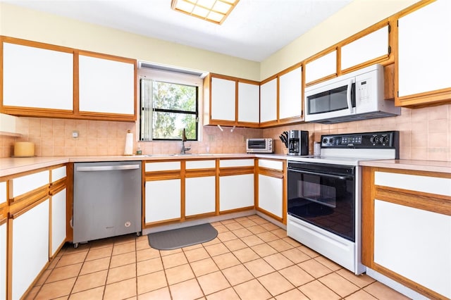 kitchen with range with electric stovetop, light countertops, decorative backsplash, white microwave, and dishwasher