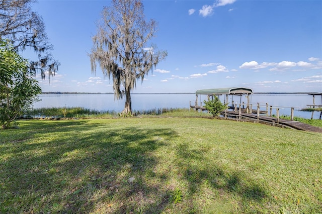 view of dock featuring a water view and a lawn