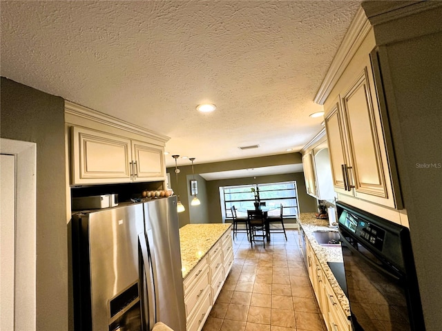 kitchen with stainless steel refrigerator with ice dispenser, light tile patterned floors, hanging light fixtures, cream cabinets, and oven