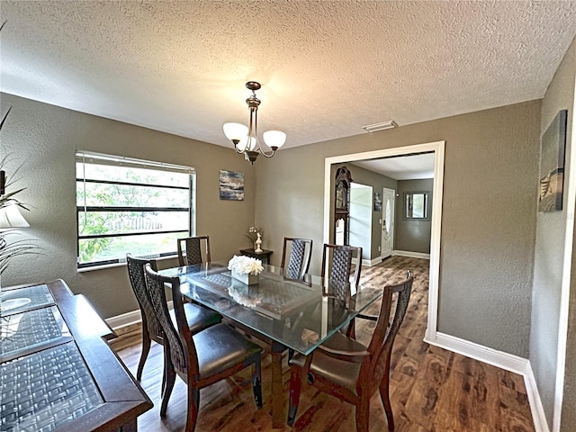 dining room featuring a notable chandelier, a textured ceiling, and hardwood / wood-style floors