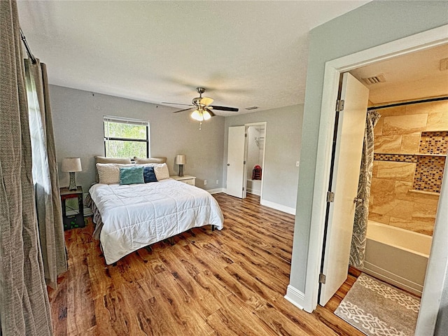 bedroom with ceiling fan, wood-type flooring, and a textured ceiling