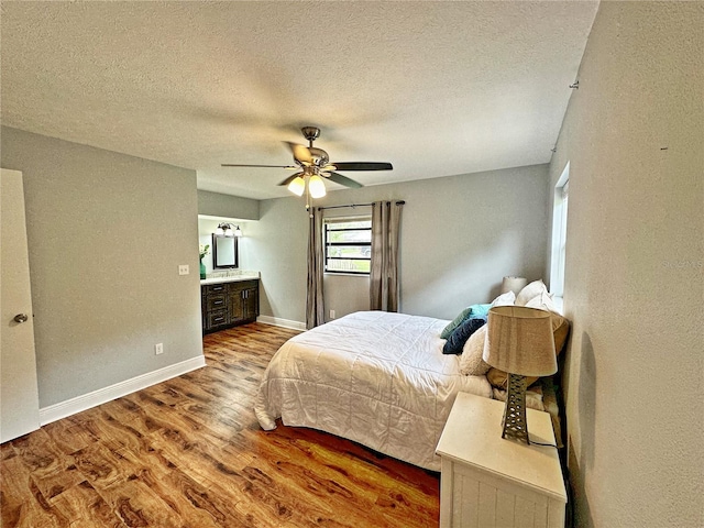 bedroom featuring ceiling fan, a textured ceiling, and wood-type flooring