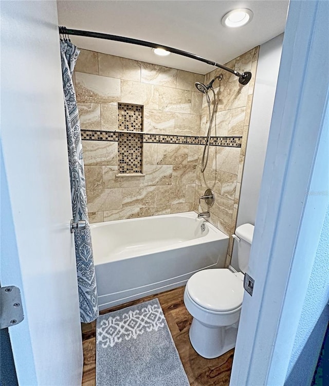 bathroom with shower / bath combo with shower curtain, wood-type flooring, and toilet