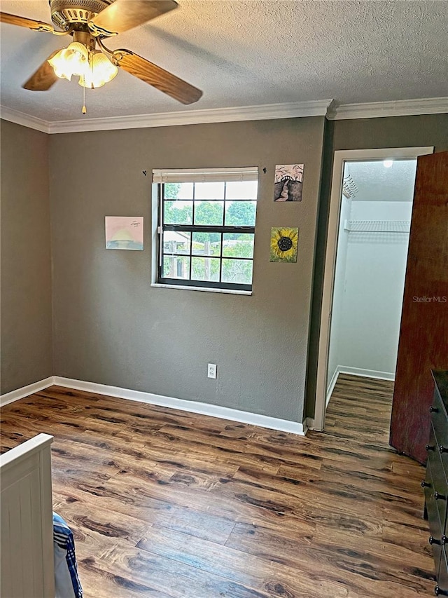 empty room with hardwood / wood-style floors, crown molding, a textured ceiling, and ceiling fan