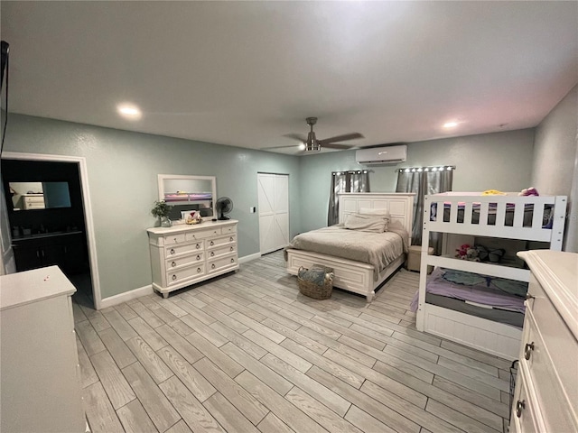 bedroom with light hardwood / wood-style floors, a wall mounted air conditioner, and ceiling fan