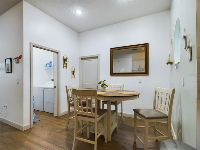 dining space with washing machine and clothes dryer, a textured ceiling, and dark hardwood / wood-style flooring