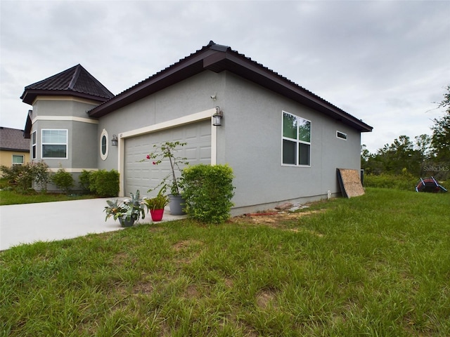 view of side of home with a garage and a lawn