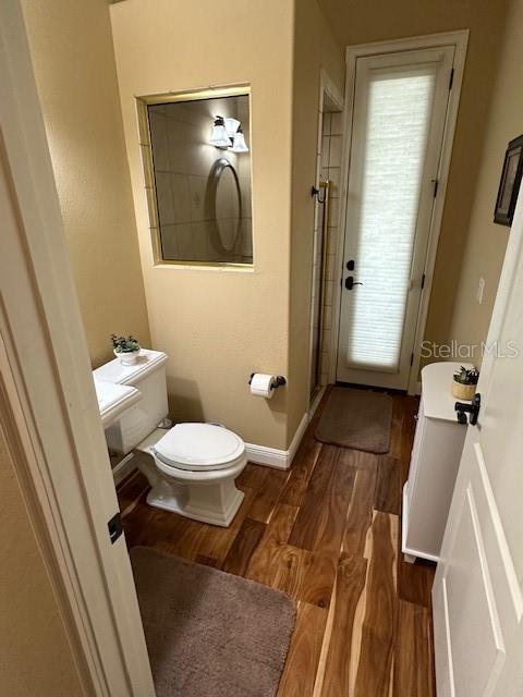 bathroom with toilet and hardwood / wood-style floors